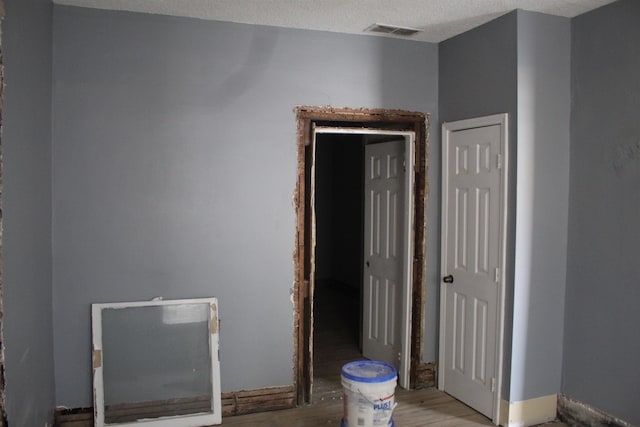 interior space featuring a textured ceiling and light wood-type flooring