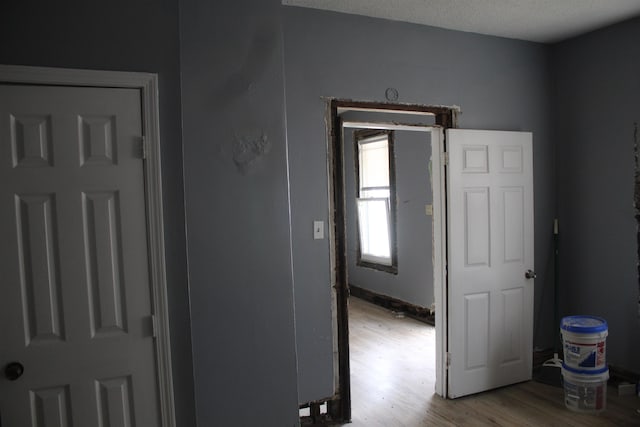 corridor featuring light hardwood / wood-style floors and a textured ceiling