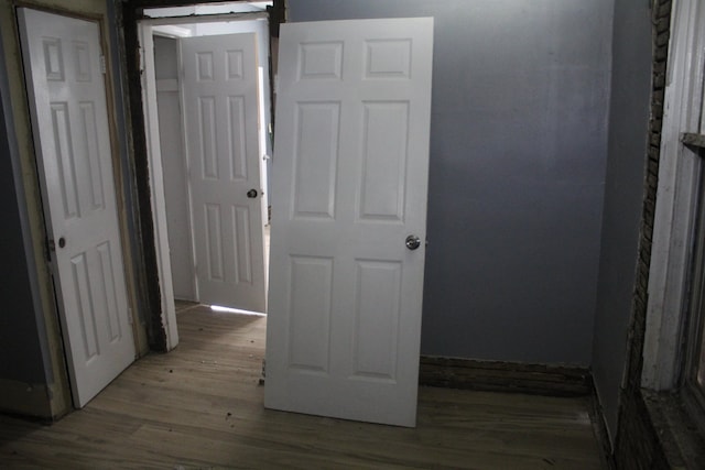 hallway with a barn door and light hardwood / wood-style floors