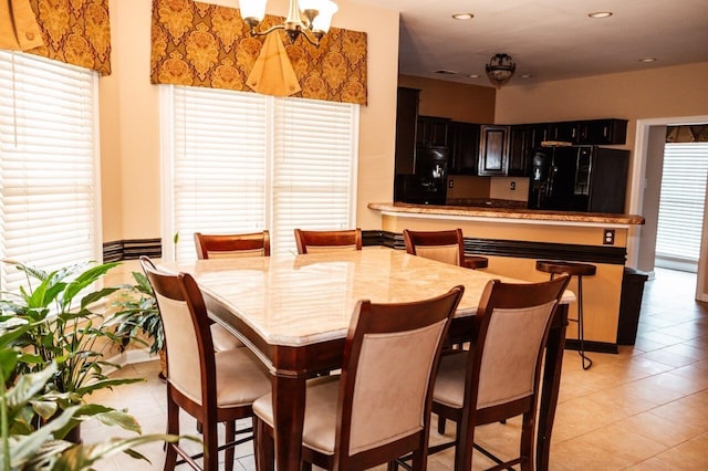 tiled dining space with a chandelier