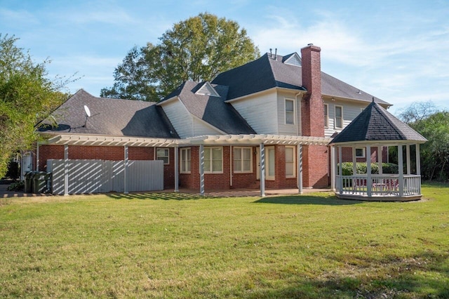 rear view of property with a lawn and a wooden deck