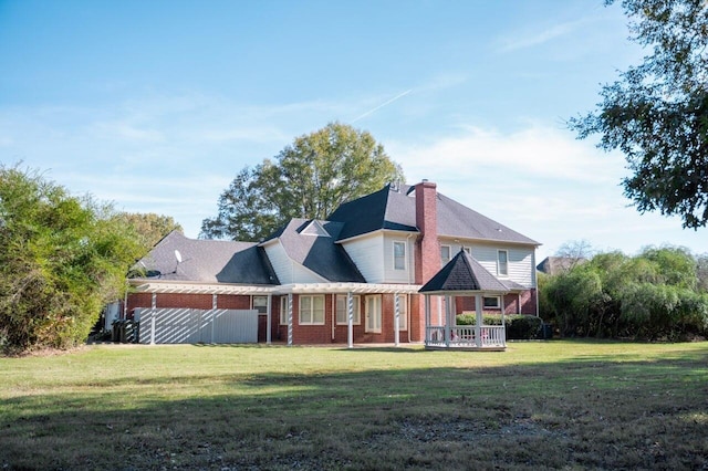 rear view of property featuring a yard