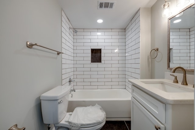 full bathroom with tile patterned floors, vanity, tiled shower / bath combo, and toilet