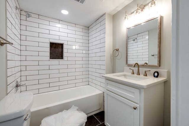 full bathroom featuring tile patterned flooring, toilet, vanity, and tiled shower / bath