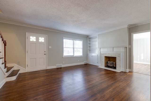 unfurnished living room featuring a high end fireplace, ornamental molding, a textured ceiling, built in features, and dark hardwood / wood-style floors