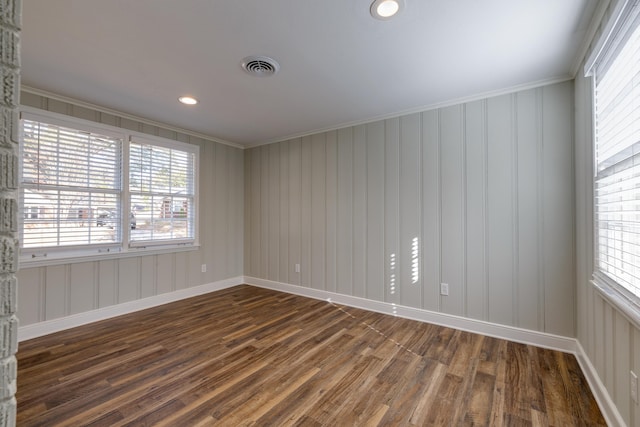 empty room with crown molding and dark wood-type flooring