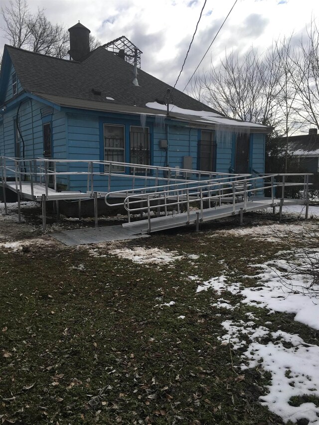 view of snow covered back of property