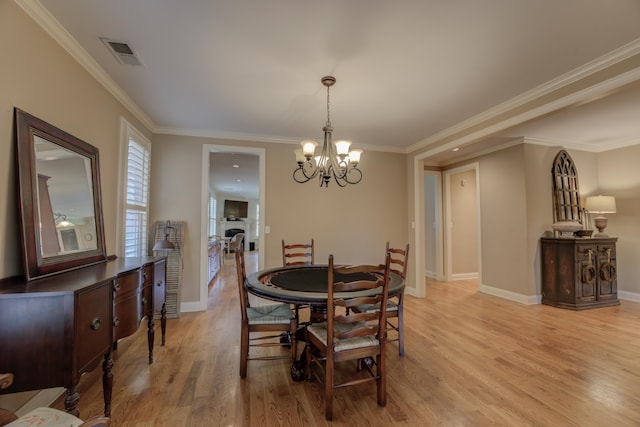 dining room featuring crown molding, light hardwood / wood-style flooring, and a chandelier