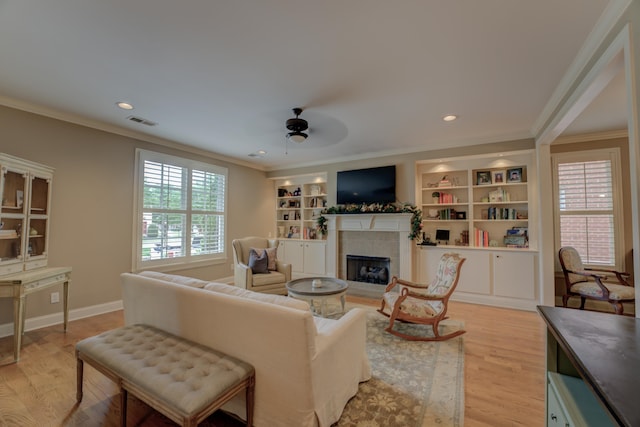 living room featuring light hardwood / wood-style flooring, plenty of natural light, and crown molding