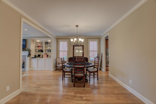 dining room with light hardwood / wood-style flooring, an inviting chandelier, and ornamental molding