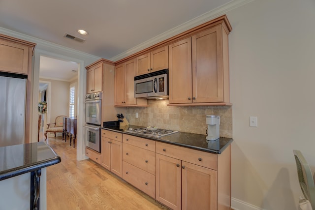 kitchen with light brown cabinets, crown molding, appliances with stainless steel finishes, tasteful backsplash, and light hardwood / wood-style floors