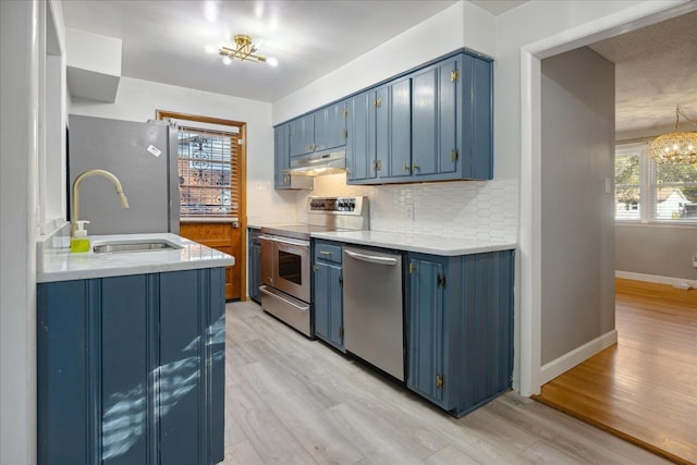 kitchen featuring light wood-type flooring, stainless steel appliances, and blue cabinetry