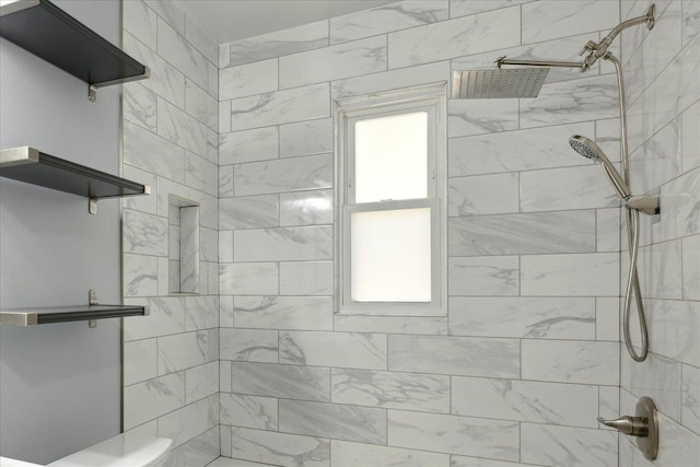 bathroom featuring toilet and tiled shower