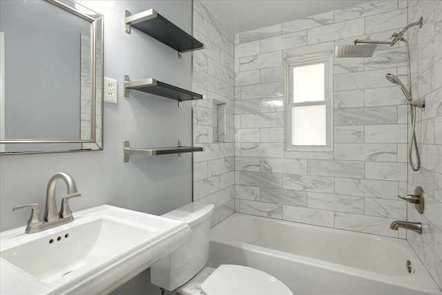 full bathroom with sink, tiled shower / bath combo, and toilet