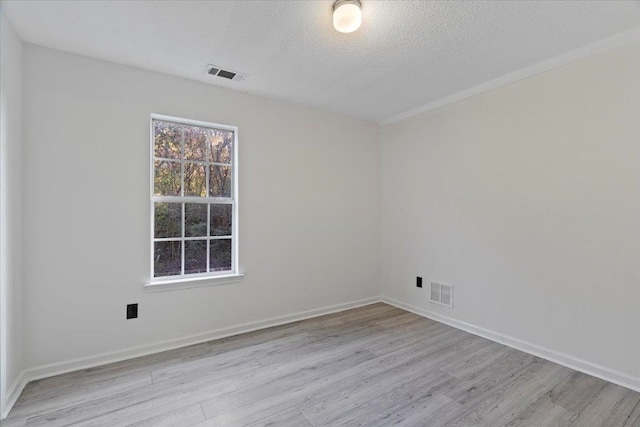 unfurnished room with a textured ceiling and light wood-type flooring