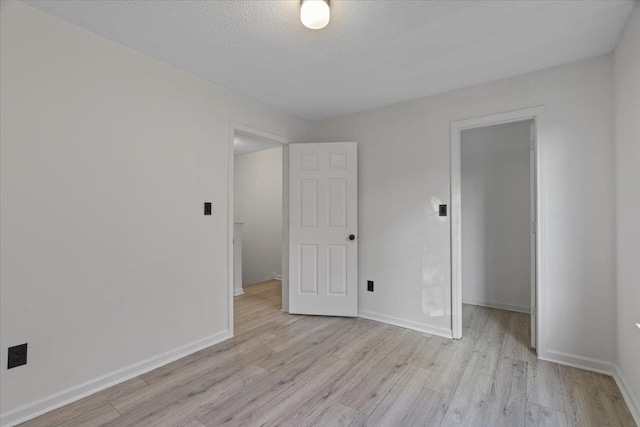 spare room with light hardwood / wood-style floors and a textured ceiling