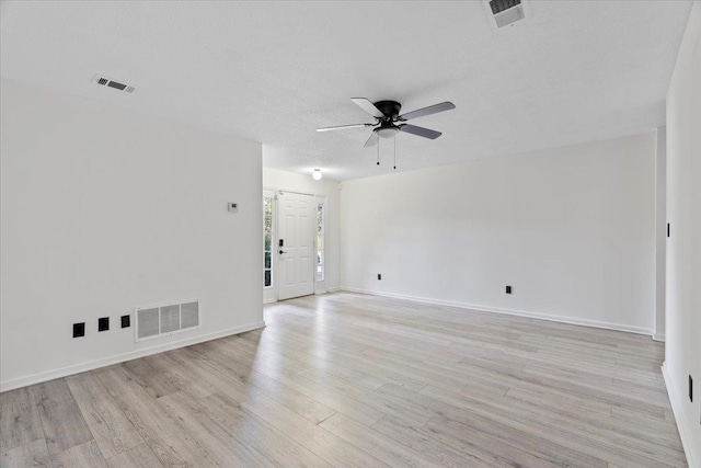 empty room featuring ceiling fan, light hardwood / wood-style flooring, and a textured ceiling