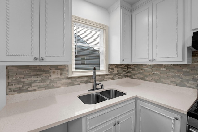 kitchen featuring white cabinetry, sink, and tasteful backsplash