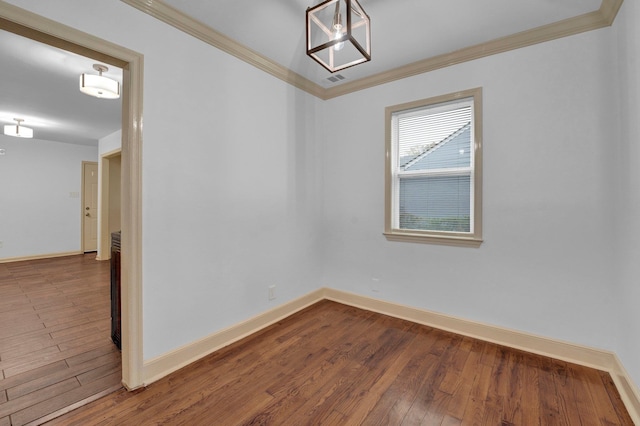 empty room with wood-type flooring and crown molding