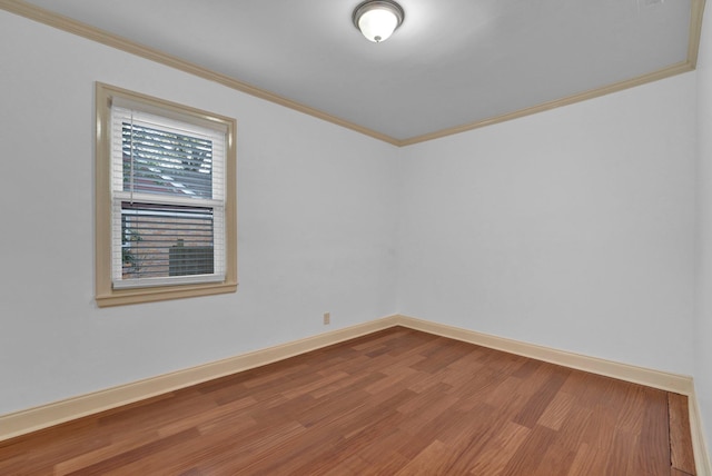 empty room with wood-type flooring and crown molding