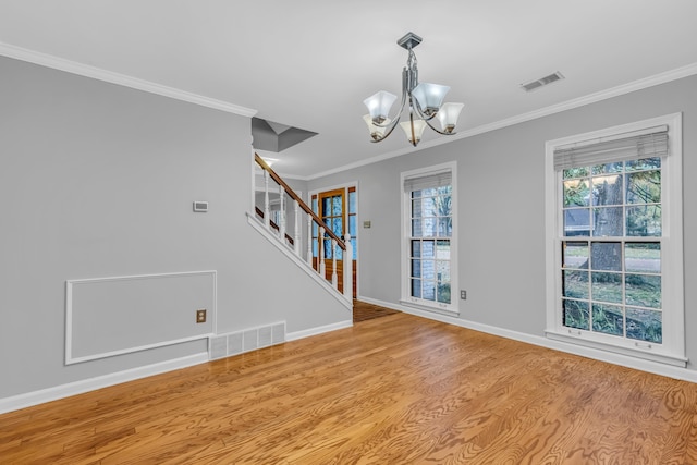 unfurnished room featuring light hardwood / wood-style floors, ornamental molding, and a notable chandelier