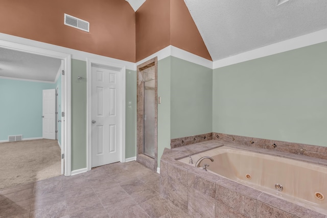 bathroom featuring a textured ceiling, high vaulted ceiling, and separate shower and tub