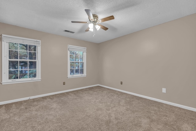 spare room featuring carpet, a textured ceiling, and ceiling fan