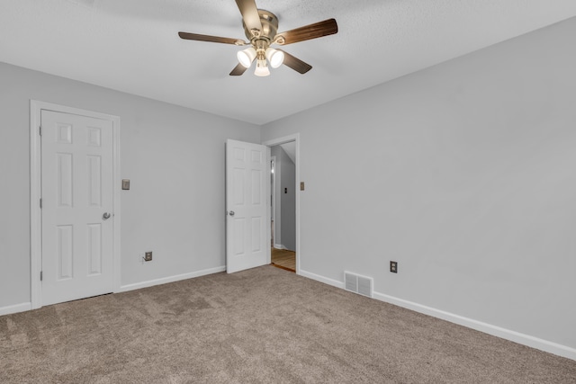 carpeted spare room with ceiling fan