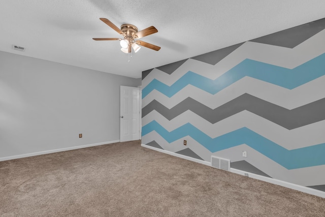 carpeted spare room featuring ceiling fan and a textured ceiling