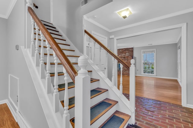 stairway featuring hardwood / wood-style floors and ornamental molding