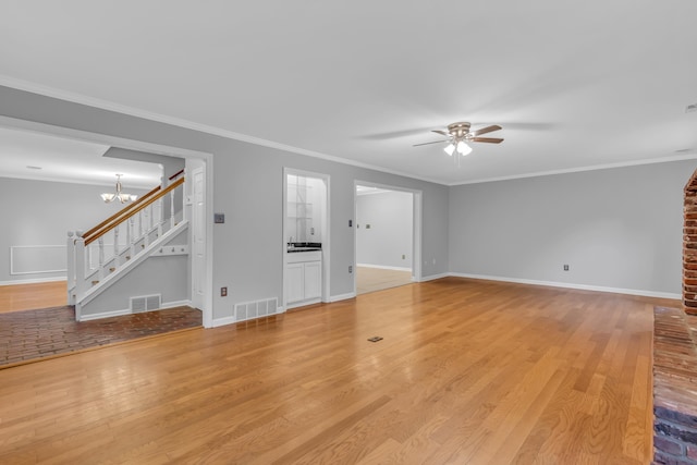 unfurnished living room featuring ceiling fan with notable chandelier, light hardwood / wood-style floors, and ornamental molding