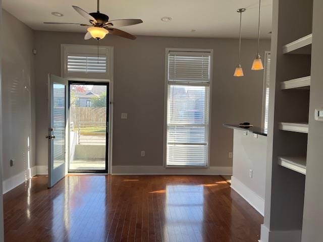 interior space with dark wood-style floors, baseboards, and a ceiling fan