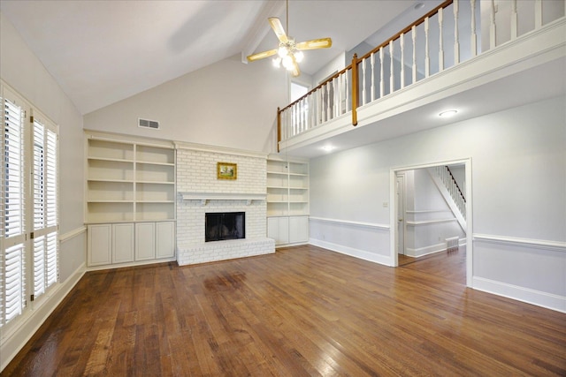 unfurnished living room featuring ceiling fan, a fireplace, high vaulted ceiling, and dark wood-type flooring