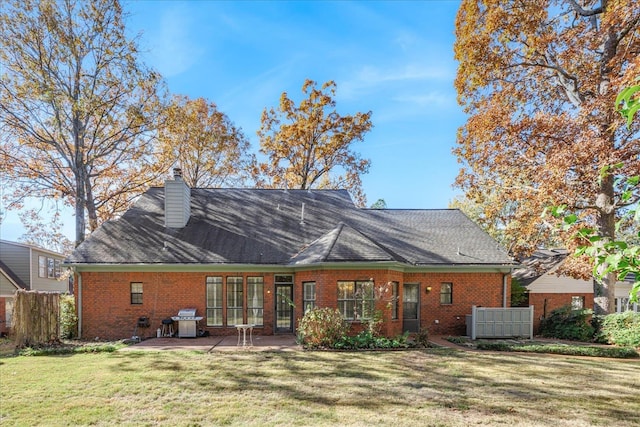 back of property featuring a lawn and a patio