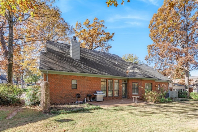 rear view of property with a yard and central AC