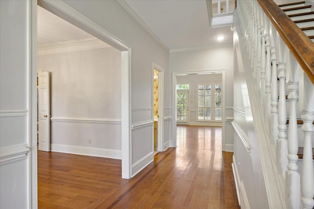 hall with wood-type flooring and ornamental molding