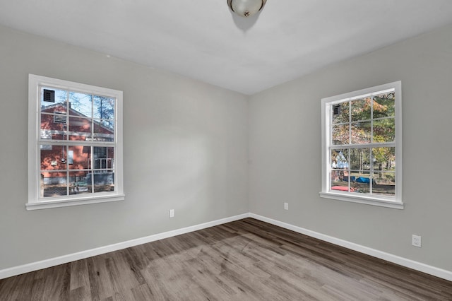 empty room with plenty of natural light and hardwood / wood-style floors