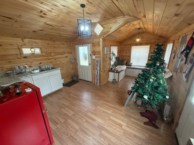 clothes washing area with wooden ceiling, wooden walls, and light hardwood / wood-style flooring