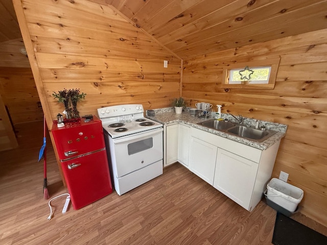 kitchen featuring sink, white electric stove, wooden walls, vaulted ceiling, and white cabinetry