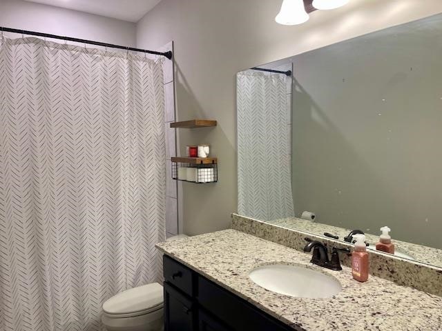 bathroom with vanity, a shower with shower curtain, and toilet