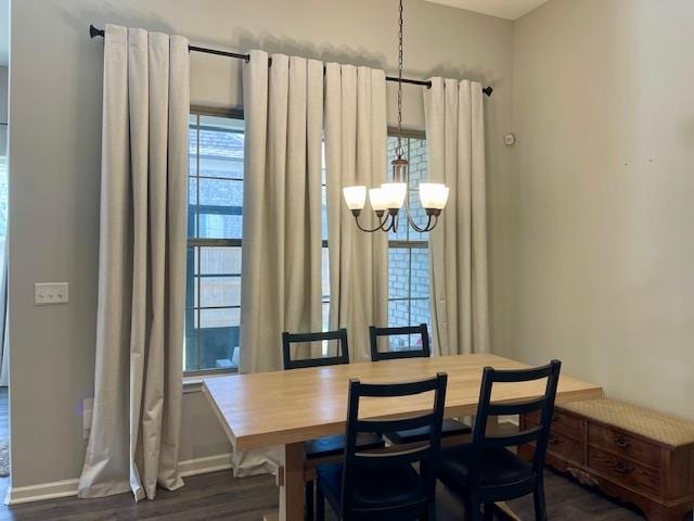 dining space with dark wood-type flooring and a chandelier