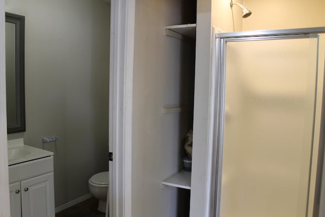 bathroom with vanity, toilet, and a shower with shower door