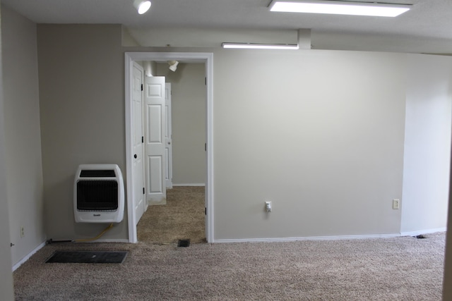 unfurnished room featuring carpet floors and heating unit