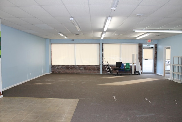 carpeted spare room featuring a paneled ceiling