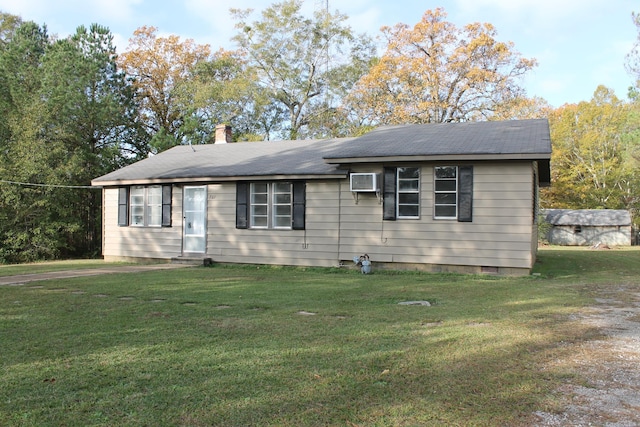 view of front of house featuring a wall unit AC and a front yard