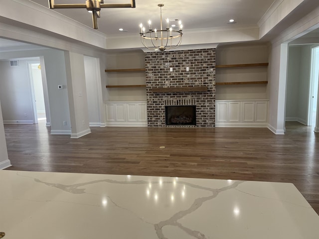 unfurnished living room with built in features, ornamental molding, and a raised ceiling