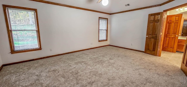 carpeted empty room featuring crown molding and ceiling fan