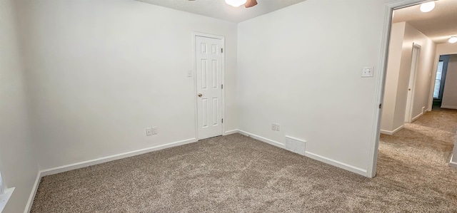 carpeted spare room featuring ceiling fan