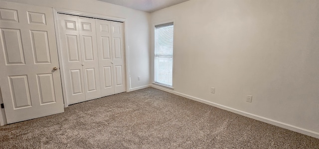 unfurnished bedroom with carpet flooring, multiple windows, and a closet