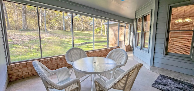 sunroom / solarium featuring a chandelier